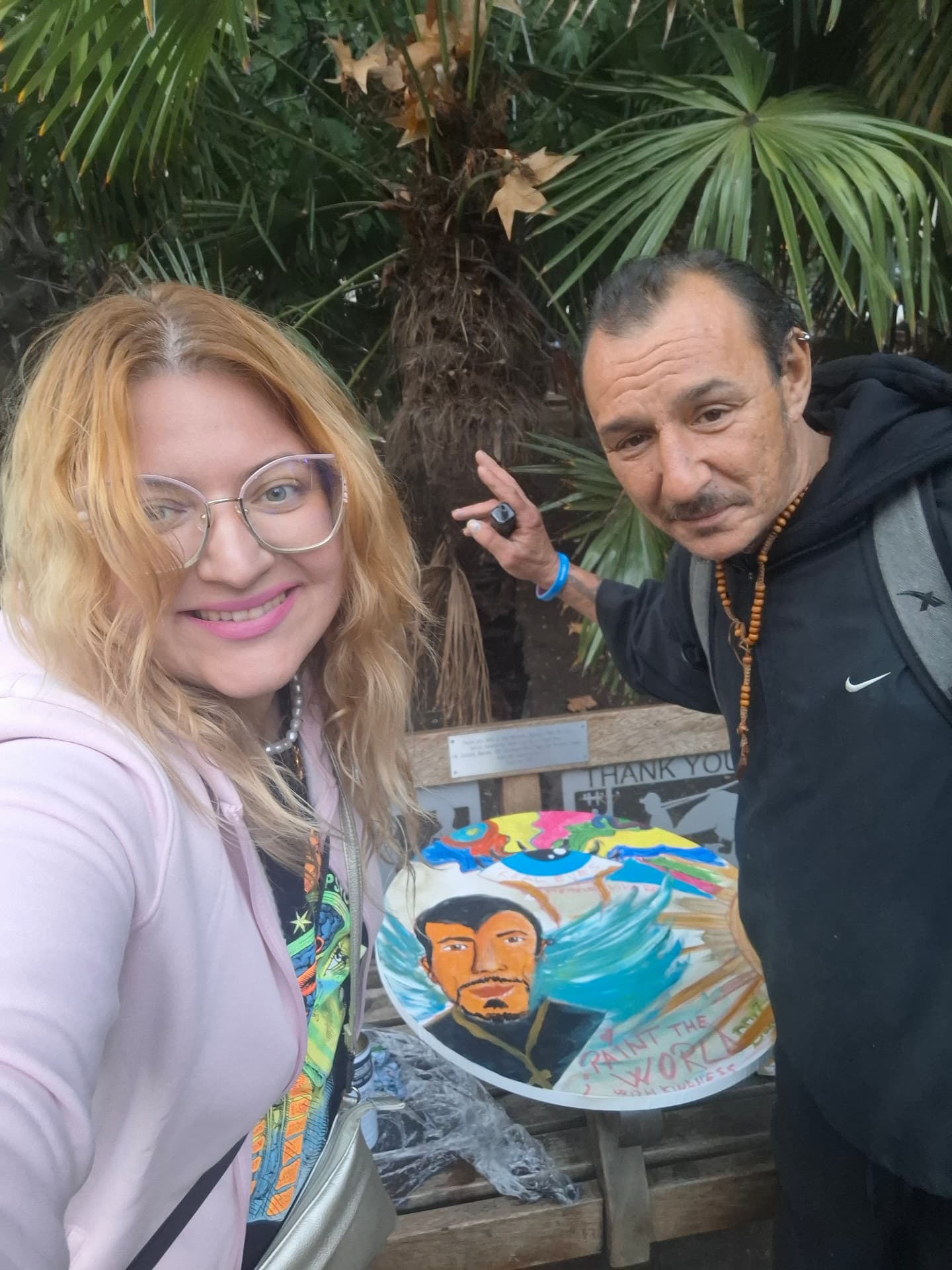 Two people smiling beside the first Paint the World with Kindness painting