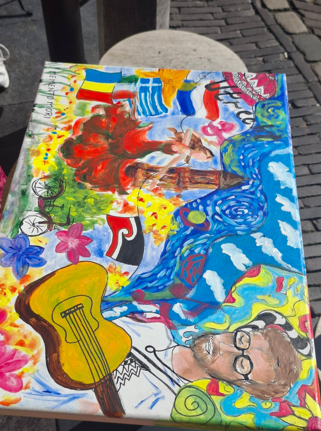 The finished acrylic canvas full of flags, flowers, a guitar and a portrait of the street musician