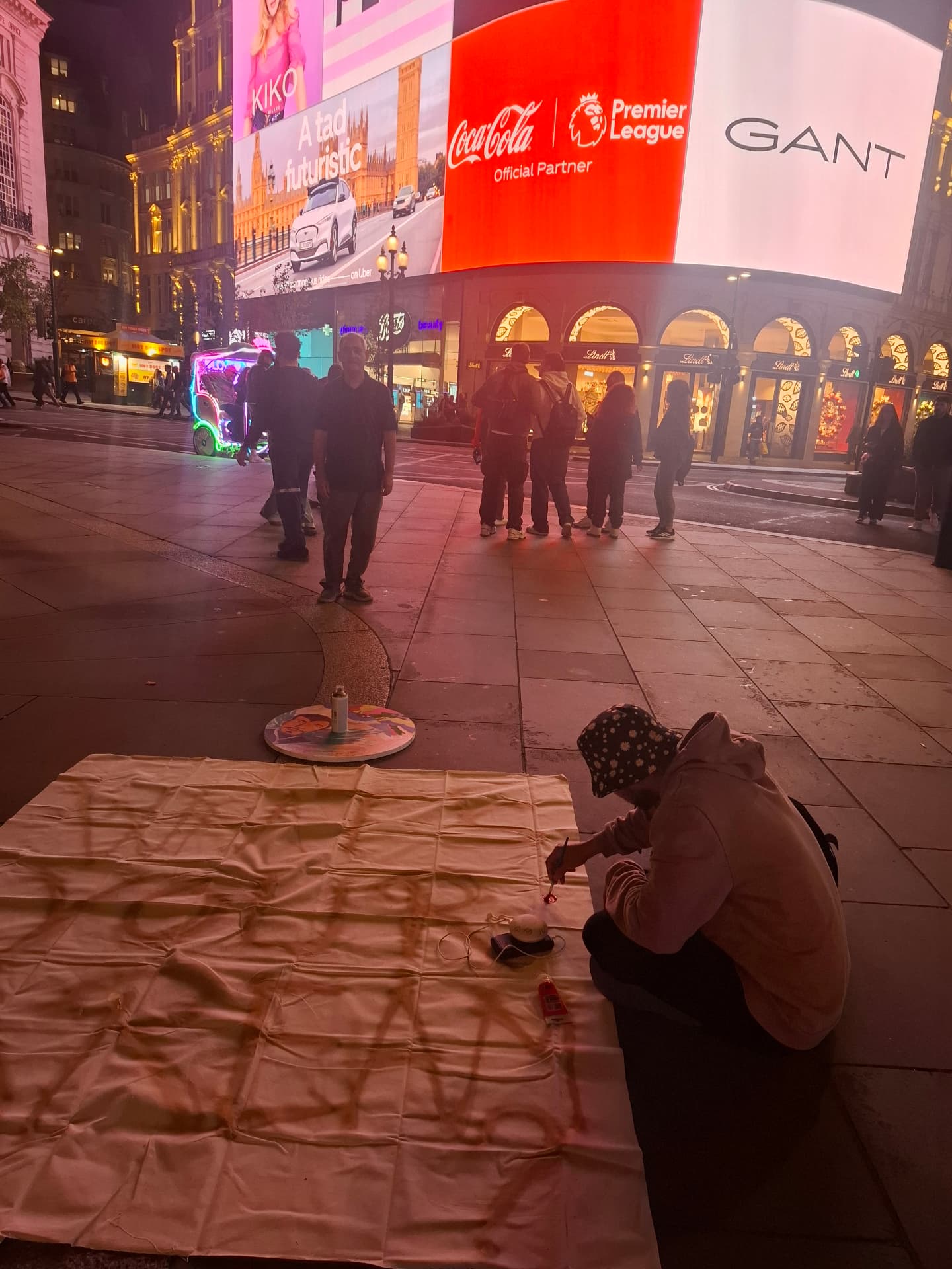 Painting the big canvas under the bright lights of Piccadilly Circus at night